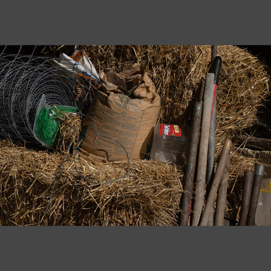 Farm tools and supplies on hay bales in a Kansas barn